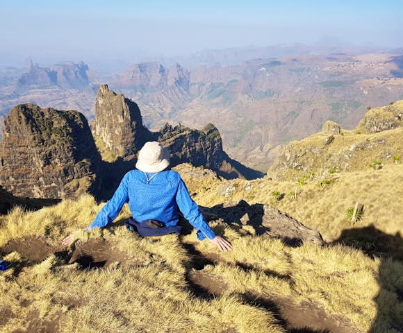 Man sitting on ledge looking at landscape in the Simien Mountains